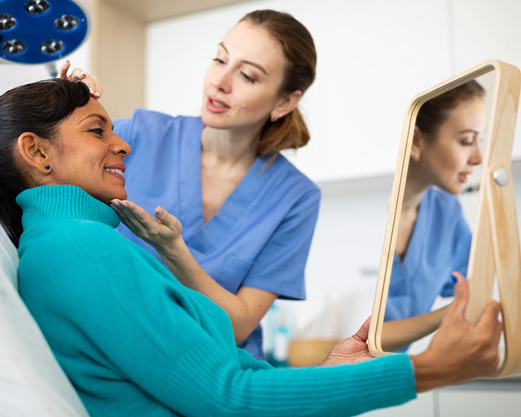 Aesthetician consultating with a client holding up a mirror